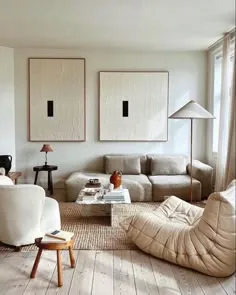 Styled neutral living room with a low sofa, matching abstract art and a Togo chair on a jute rug