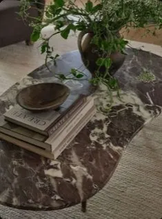 Brass ceiling spotlights above a Calacatta marble wall