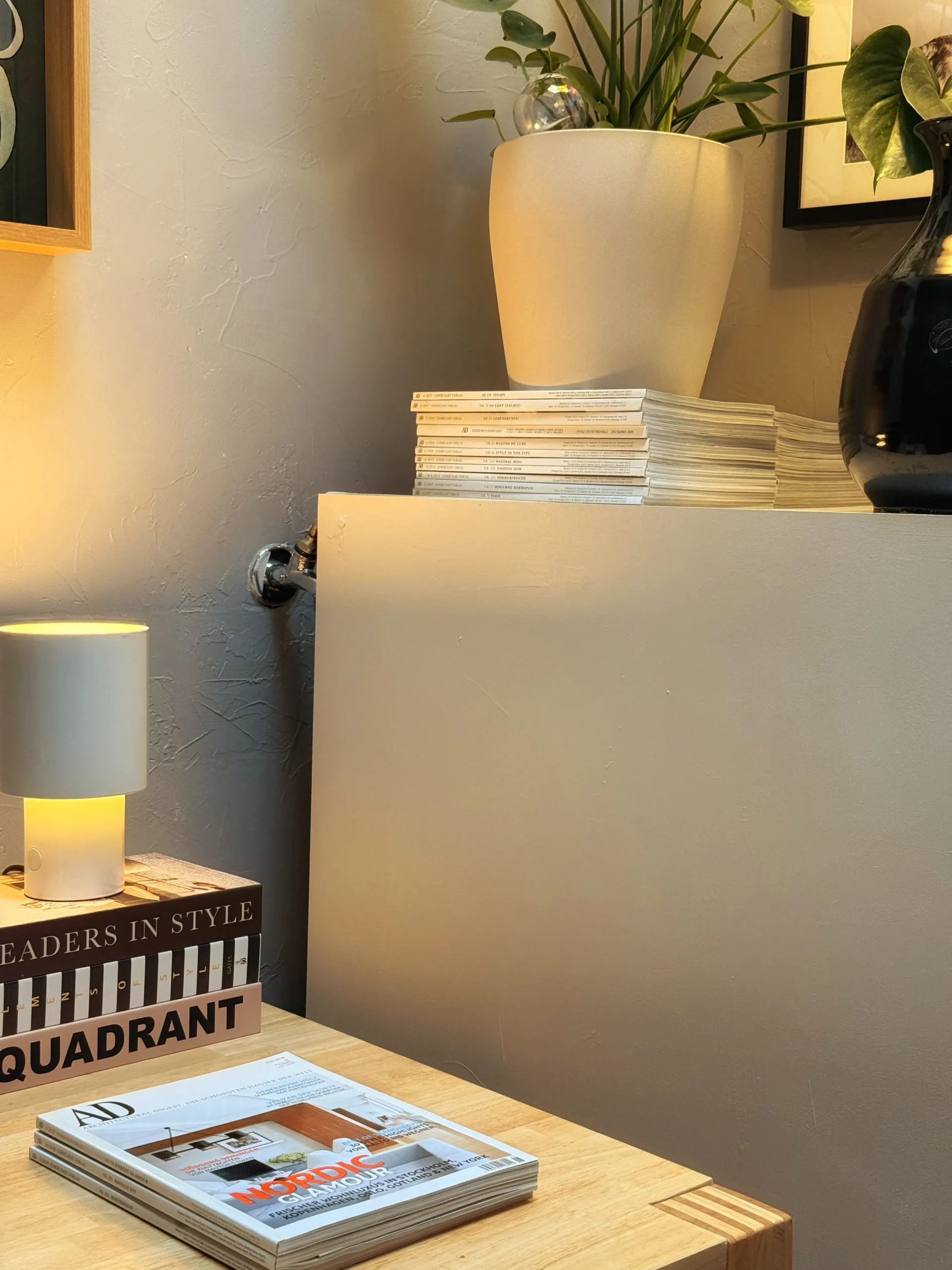Small lamp on design books beside the white pedestal built over the old sink